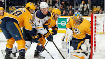 NASHVILLE, TN - DECEMBER 3: Jack Eichel #9 of the Buffalo Sabres battles between Yannick Weber #7 and Ryan Hartman #38 of the Nashville Predators as goalie Pekka Rinne #35 eyes the puck at Bridgestone Arena on December 3, 2018 in Nashville, Tennessee. (Photo by John Russell/NHLI via Getty Images)