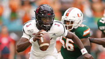 MIAMI, FLORIDA - NOVEMBER 09: Micale Cunningham #3 of the Louisville Cardinals scrambles away from Michael Pinckney #56 of the Miami Hurricanes during the first half at Hard Rock Stadium on November 09, 2019 in Miami, Florida. (Photo by Michael Reaves/Getty Images)
