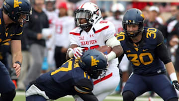 Oct 11, 2014; Lubbock, TX, USA; Texas Tech Red Raiders wide receiver Cameron Batson (80) is tackled by West Virginia Mountaineers defensive back Al-Rasheed Benton (17) in the first half at Jones AT&T Stadium. Mandatory Credit: Michael C. Johnson-USA TODAY Sports