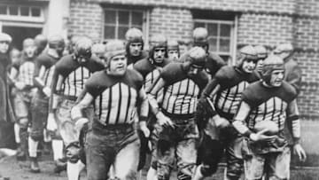 (Original Caption) Red Grange, (extreme right in front), leading his warriors to battle the University of Chicago was the scene at Memorial Stadium. In the front row and left to right are-- Bubbles Mittenwallner, Chuck Kassel, and Earl Britton. Illinois won.