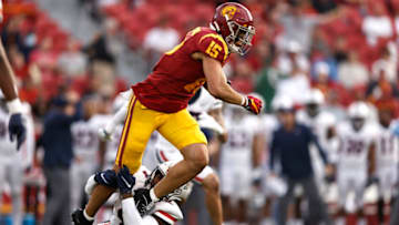 LOS ANGELES, CALIFORNIA - OCTOBER 30: Drake London #15 of the USC Trojans is tackled by Christian Roland-Wallace #4 of the Arizona Wildcats during the second quarter at Los Angeles Memorial Coliseum on October 30, 2021 in Los Angeles, California. (Photo by Michael Owens/Getty Images)