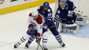 Oct 8, 2014; Toronto, Ontario, CAN; Montreal Canadiens forward Rene Bourque (17) tries to protect the puck against Toronto Maple Leafs forward Daniel Winnik (26) in front of goaltender Jonathan Bernier (45) during the second period at the Air Canada Centre. Mandatory Credit: John E. Sokolowski-USA TODAY Sports