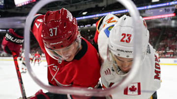 RALEIGH, NC - OCTOBER 29: Carolina Hurricanes Left Wing Andrei Svechnikov (37) and Calgary Flames Center Sean Monahan (23) battle for a puck along the boards during a game between the Calgary Flames and the Carolina Hurricanes at the PNC Arena in Raleigh, NC on October 29, 2019. (Photo by Greg Thompson/Icon Sportswire via Getty Images)