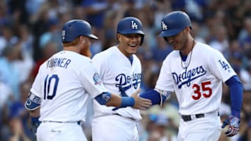 LOS ANGELES, CA - AUGUST 02: (L-R) Justin Turner #10, Manny Machado #8 and Cody Bellinger #35 of the Los Angeles Dodgers celebrate at home plate after Bellinger hit a grand slam homerun during the third inning of the MLB game against the Milwaukee Brewers at Dodger Stadium on August 2, 2018 in Los Angeles, California. (Photo by Victor Decolongon/Getty Images)