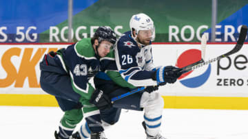 VANCOUVER, BC - FEBRUARY 19: Quinn Hughes #43 of the Vancouver Canucks tries to tie up Blake Wheeler #26 of the Winnipeg Jets during NHL hockey action at Rogers Arena on February 19, 2021 in Vancouver, Canada. (Photo by Rich Lam/Getty Images)