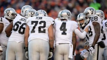 Dec 13, 2015; Denver, CO, USA; Oakland Raiders quarterback Derek Carr (4) huddles with guard Gabe Jackson (66) and tackle Donald Penn (72) and running back Latavius Murray (28) in the third quarter against the Denver Broncosat Sports Authority Field at Mile High. Mandatory Credit: Ron Chenoy-USA TODAY Sports