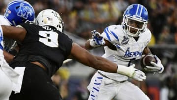 ORLANDO, FLORIDA - DECEMBER 01: Trysten Hill #9 of the UCF Knights takes down Tony Pollard #1 of the Memphis Tigers for a loss of two yards during the first quarter of the American Athletic Championship at Spectrum Stadium on December 01, 2018 in Orlando, Florida. (Photo by Julio Aguilar/Getty Images)