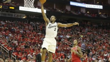 Dec 25, 2015; Houston, TX, USA; San Antonio Spurs forward Kawhi Leonard (2) dunks against Houston Rockets forward Trevor Ariza (1) in the first half of a NBA basketball game on Christmas at Toyota Center. Mandatory Credit: Thomas B. Shea-USA TODAY Sports