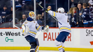 WINNIPEG, MB - NOVEMBER 16: Zach Bogosian #4 of the Buffalo Sabres celebrates with goaltender Carter Hutton #40 following a 2-1 shootout victory over the Winnipeg Jets at the Bell MTS Place on November 16, 2018 in Winnipeg, Manitoba, Canada. (Photo by Darcy Finley/NHLI via Getty Images)