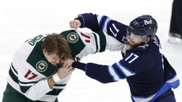 Feb 8, 2022; Winnipeg, Manitoba, CAN; Minnesota Wild left wing Marcus Foligno (17) and Winnipeg Jets center Adam Lowry (17) fight in the third period at Canada Life Centre. Mandatory Credit: James Carey Lauder-USA TODAY Sports