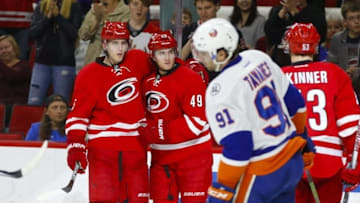 Mar 26, 2016; Raleigh, NC, USA; Carolina Hurricanes forward Victor Rask (49) is congratulated by teammate Noah Hanifin (5) after his second period goal against the New York Islanders at PNC Arena. Mandatory Credit: James Guillory-USA TODAY Sports
