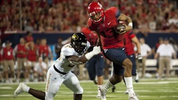 Sep 10, 2016; Tucson, AZ, USA; Arizona Wildcats quarterback Brandon Dawkins (13) runs the ball under pressure from Grambling State Tigers defensive back Derrick Dixon (30) during the third quarter at Arizona Stadium. Mandatory Credit: Casey Sapio-USA TODAY Sports