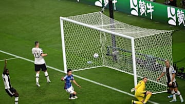 Japan's second goal bounces into the net as Germany goalie Manuel Neuer (right) and defender Niklas Sule (left react). (Photo by ANNE-CHRISTINE POUJOULAT/AFP via Getty Images)