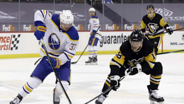 Mar 24, 2021; Pittsburgh, Pennsylvania, USA; Buffalo Sabres center Casey Mittelstadt (37) moves the puck against Pittsburgh Penguins center Sam Lafferty (18) during the first period at PPG Paints Arena. Mandatory Credit: Charles LeClaire-USA TODAY Sports