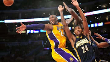 November 27, 2012; Los Angeles, CA, USA; Los Angeles Lakers shooting guard Kobe Bryant (24) turns the ball over against the defense of Indiana Pacers small forward Paul George (24) during the first half at Staples Center. Mandatory Credit: Gary A. Vasquez-USA TODAY Sports