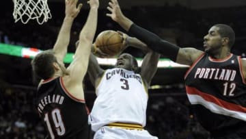 Dec 17, 2013; Cleveland, OH, USA; Cleveland Cavaliers shooting guard Dion Waiters (3) drives between Portland Trail Blazers power forward LaMarcus Aldridge (12) and center Joel Freeland (19) in the fourth quarter at Quicken Loans Arena. Mandatory Credit: David Richard-USA TODAY Sports