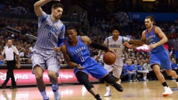 Oct 30, 2015; Orlando, FL, USA; Oklahoma City Thunder guard Russell Westbrook (0) drives to the basket as Orlando Magic center Nikola Vucevic (9) defends during the first quarter at Amway Center. Mandatory Credit: Kim Klement-USA TODAY Sports