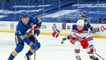 BUFFALO, NY - JANUARY 26: Jack Eichel #9 of the Buffalo Sabres skates up ice with the puck as Adam Fox #23 of the New York Rangers defends during the second period at KeyBank Center on January 26 , 2021 in Buffalo, New York. (Photo by Kevin Hoffman/Getty Images)