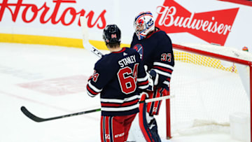 Nov 11, 2021; Winnipeg, Manitoba, CAN; Winnipeg Jets goalie Connor Hellebuyck (37) celebrates his win against the San Jose Sharks at the end of the third period at Canada Life Centre. Mandatory Credit: Terrence Lee-USA TODAY Sports