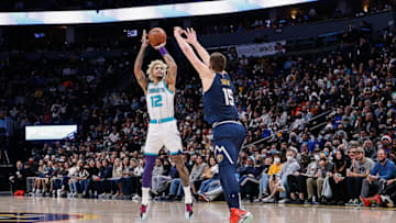 Dec 23, 2021; Denver, Colorado, USA; Charlotte Hornets guard Kelly Oubre Jr. (12) attempts a shot against Denver Nuggets center Nikola Jokic (15) in the third quarter at Ball Arena. Mandatory Credit: Isaiah J. Downing-USA TODAY Sports
