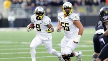 Oct 12, 2013; Seattle, WA, USA; Oregon Ducks running back Byron Marshall (9) carries the ball with offensive linesman Hroniss Grasu (55) blocking during the 2nd half against the Washington Huskies at Husky Stadium. Oregon defeated Washington 45-24. Mandatory Credit: Steven Bisig-USA TODAY Sports