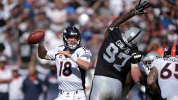 Oct 11, 2015; Oakland, CA, USA; Denver Broncos quarterback Peyton Manning (18) throws a pass under pressure by Oakland Raiders defensive end Mario Edwards Jr. (97) at O.co Coliseum. Mandatory Credit: Kirby Lee-USA TODAY Sports