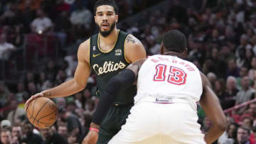 Jayson Tatum #0 of the Boston Celtics dribbles the basketball while being defended by Bam Adebayo #13 of the Miami Heat (Photo by Eric Espada/Getty Images)