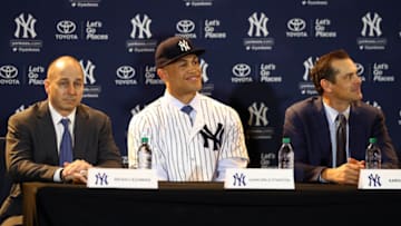 ORLANDO, FL - DECEMBER 11: General Manager Brian Cashman, Giancarlo Stanton and Manager Aaron Boone are seen during a press conference where Stanton is introduced as a member of the New York Yankees at the 2017 Winter Meetings at the Walt Disney World Swan and Dolphin Resort on Monday, December 11, 2017 in Orlando, Florida. (Photo by Alex Trautwig/MLB Photos via Getty Images)