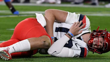 Nov 28, 2020; Pasadena, California, USA; Arizona Wildcats quarterback Grant Gunnell (17) grabs his shoulder after getting hit on the first play of the game against the UCLA Bruins at Rose Bowl. Mandatory Credit: Robert Hanashiro-USA TODAY Sports