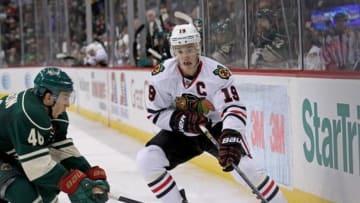 Dec 5, 2013; Saint Paul, MN, USA; Chicago Blackhawks forward Jonathan Toews (19) passes around Minnesota Wild defenseman Jared Spurgeon (46) during the third period at Xcel Energy Center. The Wild defeated the Blackhawks 4-3. Mandatory Credit: Brace Hemmelgarn-USA TODAY Sports