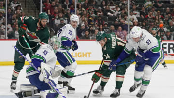 Mar 24, 2022; Saint Paul, Minnesota, USA; Vancouver Canucks goalie Thatcher Demko (35) makes a stop on Minnesota Wild center Joel Eriksson Ek (14) as defenseman Tyler Myers (57) defends during the second period at Xcel Energy Center. Mandatory Credit: Nick Wosika-USA TODAY Sports