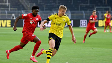 DORTMUND, GERMANY - MAY 26: Erling Haaland of Borussia Dortmund runs with the ball past Alphonso Davies of Bayern Munich during the Bundesliga match between Borussia Dortmund and FC Bayern Muenchen at Signal Iduna Park on May 26, 2020 in Dortmund, Germany. (Photo by Federico Gambarini/Pool via Getty Images)