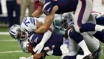 Oct 11, 2015; Arlington, TX, USA; New England Patriots quarterback Tom Brady (12) is sacked by Dallas Cowboys linebacker Rolando McClain (55) and defensive end Greg Hardy (76) at AT&T Stadium. Patriots tackle Nate Solder (77) trying to block out Hardy (76). Mandatory Credit: Erich Schlegel-USA TODAY Sports