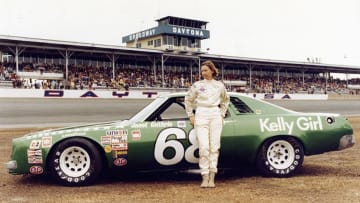 DAYTONA BEACH, FL - FEBRUARY 20: Janet Guthrie #68 stands in front of her car before the 1977 Winston Cup Daytona 500 on February 20, 1977 at the Daytona International Speedway in Daytona Beach, Florida. (Photo by ISC Archives via Getty Images)