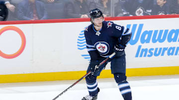 WINNIPEG, MB - MARCH 14: Jacob Trouba #8 of the Winnipeg Jets plays the puck down the ice during third period action against the Boston Bruins at the Bell MTS Place on March 14, 2019 in Winnipeg, Manitoba, Canada. The Jets defeated the Bruins 4-3. (Photo by Jonathan Kozub/NHLI via Getty Images)