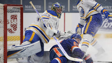 Mar 4, 2021; Uniondale, New York, USA; New York Islanders center Casey Cizikas (53) crashes into Buffalo Sabres goalie Jonas Johansson (34) during the second period at Nassau Veterans Memorial Coliseum. Mandatory Credit: Brad Penner-USA TODAY Sports