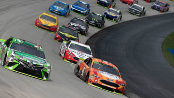 DOVER, DE - OCTOBER 07: Kyle Busch, driver of the #18 Interstate Batteries Toyota, and Kevin Harvick, driver of the #4 Busch Outdoors Ford, lead the field during the Monster Energy NASCAR Cup Series Gander Outdoors 400 at Dover International Speedway on October 7, 2018 in Dover, Delaware. (Photo by Brian Lawdermilk/Getty Images)