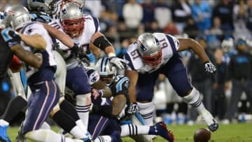 Nov 18, 2013; Charlotte, NC, USA; New England Patriots guard Logan Mankins (70) and tackle Marcus Cannon (61) chase a fumble that is recovered by Carolina Panthers defensive end Mario Addison (97) (not pictured) in the second quarter at Bank of America Stadium. Mandatory Credit: Bob Donnan-USA TODAY Sports