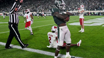 Oct 15, 2022; East Lansing, Michigan, USA; Michigan State Spartans wide receiver Jayden Reed (1) catches a touchdown pass in spite of Wisconsin Badgers cornerback Ricardo Hallman (2) in a second overtime period to win the game, 34-28, at Spartan Stadium. Mandatory Credit: Dale Young-USA TODAY Sports