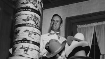 Gene Autry with his collection of Stetson hats, circa 1950s. Getty