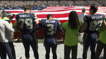 Sep 11, 2016; Seattle, WA, USA; Seattle Seahawks offensive tackle Bradley Sowell (78), left, quarterback Russell Wilson (3) and tight end Luke Willson (82) join arms during the National Anthem before the start of a game against the Miami Dolphins at CenturyLink Field. Mandatory Credit: Troy Wayrynen-USA TODAY Sports