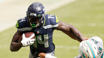MIAMI GARDENS, FLORIDA - OCTOBER 04: DK Metcalf #14 of the Seattle Seahawks breaks a tackle from Nik Needham #40 of the Miami Dolphins during the fourth quarter at Hard Rock Stadium on October 04, 2020 in Miami Gardens, Florida. (Photo by Michael Reaves/Getty Images)