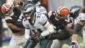 Nov 22, 2020; Cleveland, Ohio, USA; Philadelphia Eagles quarterback Carson Wentz (11) is sacked by Cleveland Browns defensive end Olivier Vernon (54) during the second quarter at FirstEnergy Stadium. Mandatory Credit: Scott Galvin-USA TODAY Sports