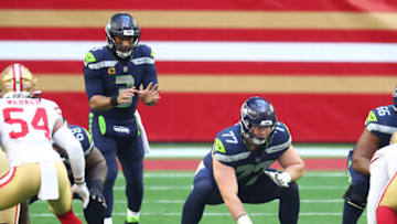Jan 3, 2021; Glendale, Arizona, USA; Seattle Seahawks guard Ethan Pocic (77) prepares to snap the ball to quarterback Russell Wilson (3) against the San Francisco 49ers at State Farm Stadium. Mandatory Credit: Mark J. Rebilas-USA TODAY Sports
