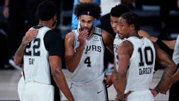 Aug 2, 2020; Lake Buena Vista, USA; San Antonio Spurs' Derrick White (4) confers with teammates Rudy Gay (22), DeMar DeRozan (10) and others during the second half of an NBA basketball game against the Memphis Grizzlies, Sunday, Aug. 2, 2020, in Lake Buena Vista, Fla. Mandatory Credit: Ashley Landis/Pool Photo via USA TODAY Sports