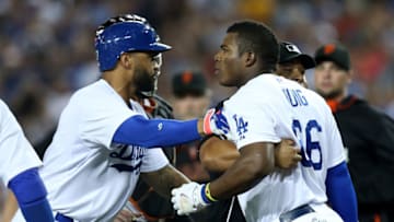 LOS ANGELES, CA - SEPTEMBER 23: Yasiel Puig #66 of the Los Angeles Dodgers is restrained by Matt Kemp #27 and home plate umpire Adrian Johnson after puig was hit by a pitch from Madison Bumgarner of the San Francisco Giants at Dodger Stadium on September 23, 2014 in Los Angeles, California. (Photo by Stephen Dunn/Getty Images)