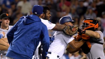 LOS ANGELES, CA - AUGUST 14: Yasiel Puig #66 of the Los Angeles Dodgers and Nick Hundley #5 of the San Francisco Giants fight as first base coach George Lombard #29 comes between the two during the seventh inning at Dodger Stadium on August 14, 2018 in Los Angeles, California. Both players would be ejected from the game. (Photo by Harry How/Getty Images)