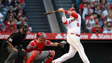 ANAHEIM, CALIFORNIA - JUNE 26: Justin Bour #41 of the Los Angeles Angels of Anaheim reacts after hitting a three-run homerun as umpire Pat Hoberg and Curt Casali #12 of the Cincinnati Reds look on during the eighth inning of a game against the Cincinnati Reds at Angel Stadium of Anaheim on June 26, 2019 in Anaheim, California. (Photo by Sean M. Haffey/Getty Images)