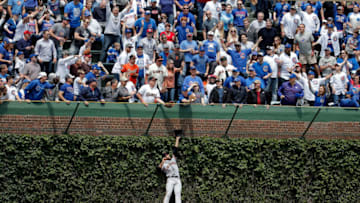 CHICAGO, IL - MAY 25: Mac Williamson #51 of the San Francisco Giants leaps in to the ivy to in an attempt to make a catch as fans reach for the home run ball of Kris Bryant #17 of the Chicago Cubs (not pictured) during the first inning at Wrigley Field on May 25, 2017 in Chicago, Illinois. (Photo by Jon Durr/Getty Images)