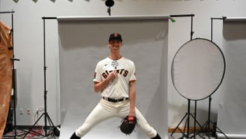 SF Giants pitcher Sean Hjelle (84), who is 6'11' helps out photographers so he so he fits in the seamless backdrop during spring training media day at Scottsdale Stadium. (Jayne Kamin-Oncea-USA TODAY Sports)